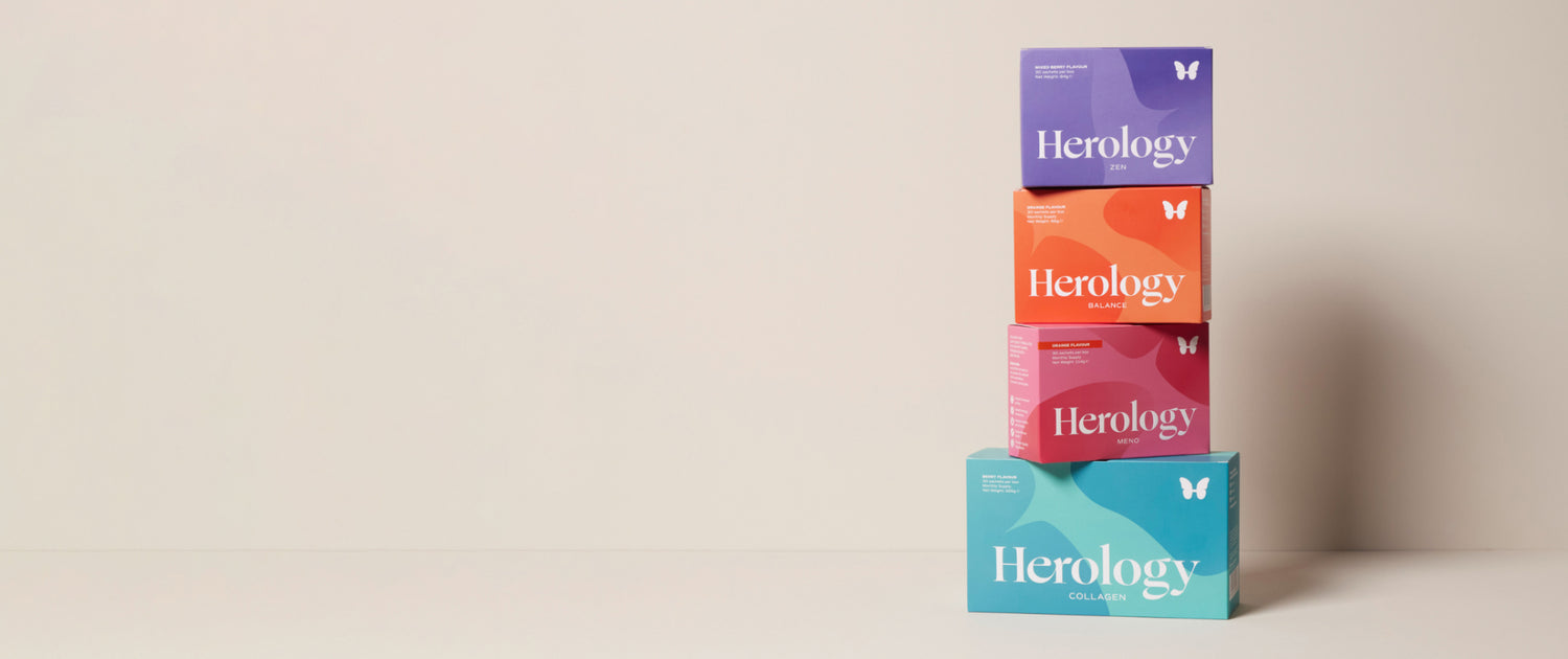 4 of Herology women's supplements boxes stacked one over the other on a minimalist shelf